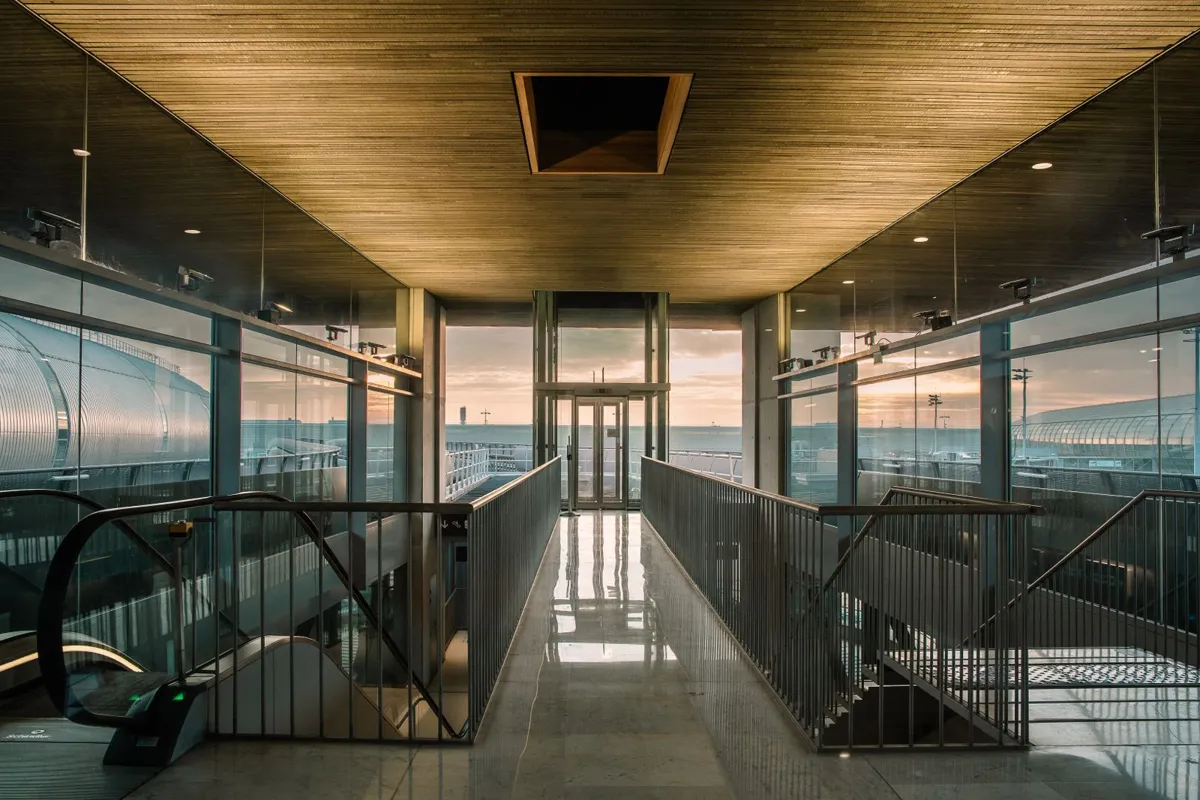 Airport terminal corridor lit by early sunlight