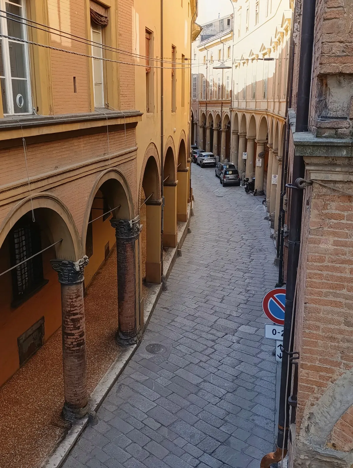 A street beneath historic porticoes in Bologna