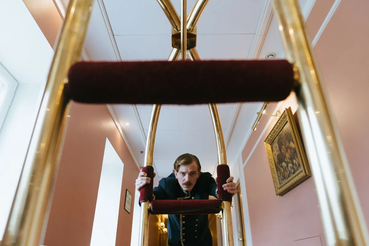 Hotel porter moving a luggage trolley