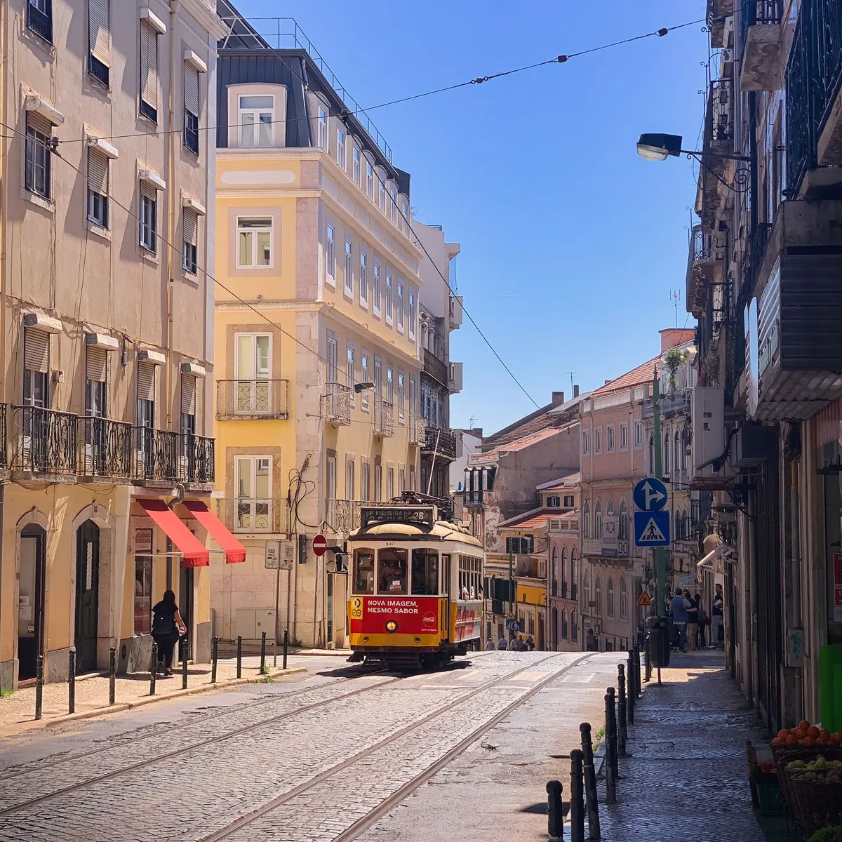 A Lisbon tram on a sunlit historic street