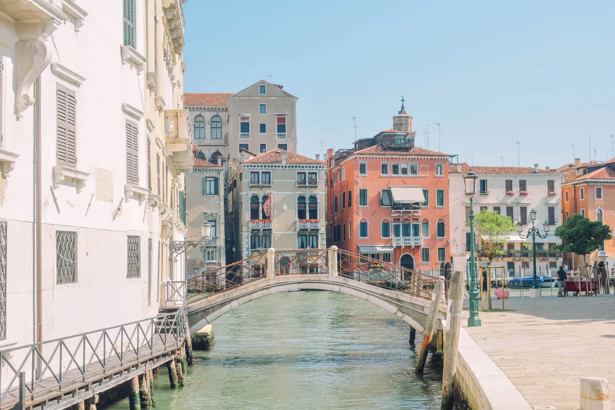 A smaller Venice canal with a pedestrian bridge